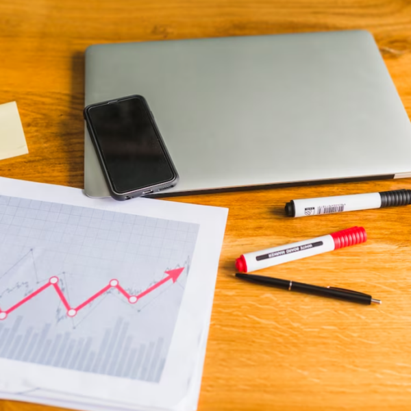 graph with laptop and cellphone over wooden desk