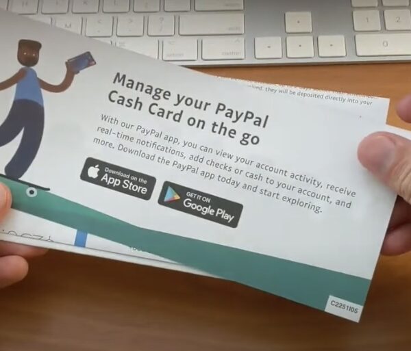 Hand holding a brochure with the text 'Manage your PayPal Cash Card on the go