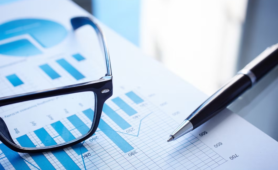 Close-up view of eyeglasses, pen, and financial report placed together