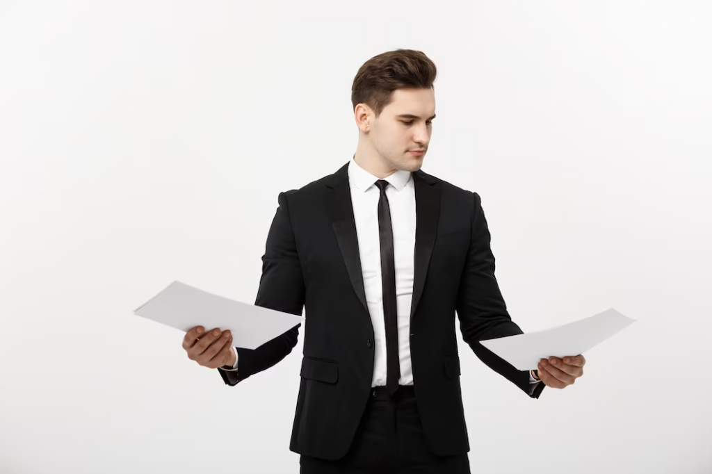 Man in a suit holding and examining two documents in both hands