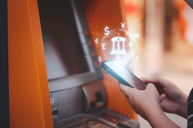 Person using a phone at an ATM with bank transfer graphics on top of the screen